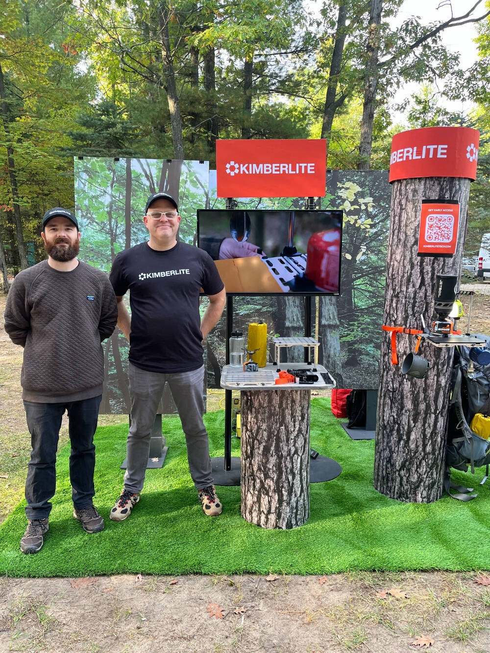 Casey McKeller and Robin Petersen pose in front of products from their outdoor tech company, Kimberlite